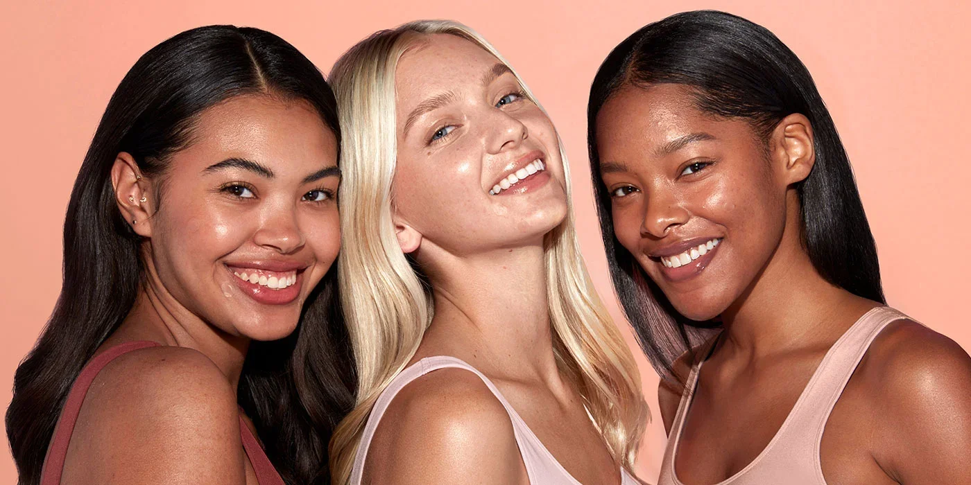 Three smiling women with glowing skin